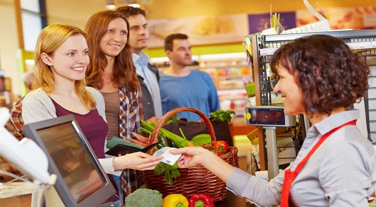 Supermarket cashier using AxoOne grocery POS software with barcode scanner